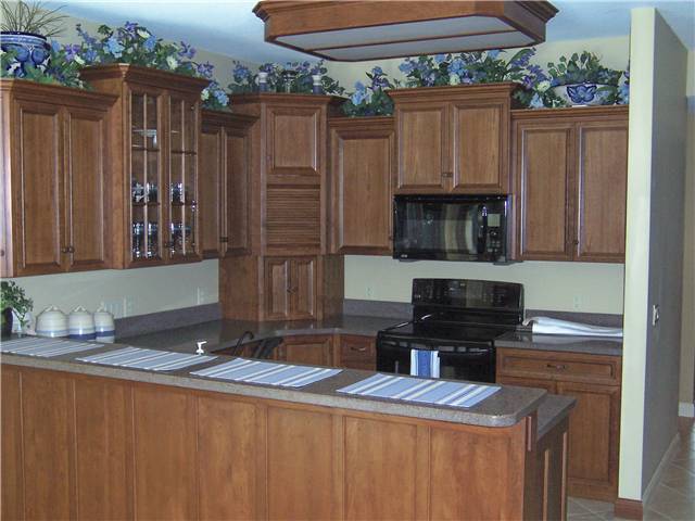 Cherry cabinets - Flat panel miter corner doors - Full overlay style - Solid surface countertops